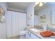 Bathroom showcasing a granite countertop, large mirror, and shower-tub combo with a white curtain at 1210 Wolford Dr, Trinity, FL 34655