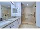 Bathroom featuring granite countertops, double sinks, a large mirror, and a glass shower enclosure at 1210 Wolford Dr, Trinity, FL 34655