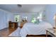 Bright bedroom with wood-look floors, a white bedspread, and natural light from two windows at 1210 Wolford Dr, Trinity, FL 34655