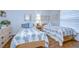 Comfortable bedroom featuring two beds, matching floral linens, and light wood furnishings at 1210 Wolford Dr, Trinity, FL 34655