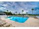 Inviting community pool with palm trees and water feature, offering a relaxing and picturesque setting at 1210 Wolford Dr, Trinity, FL 34655