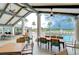 Inviting covered patio with tables and seating, overlooking the pool and lake with fountain views at 1210 Wolford Dr, Trinity, FL 34655