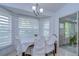 Bright dining area with a decorative chandelier and large windows, showcasing an inviting atmosphere at 1210 Wolford Dr, Trinity, FL 34655