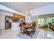 Open-concept dining area with a chandelier, seamlessly connected to the kitchen and sunroom at 1210 Wolford Dr, Trinity, FL 34655