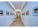 Well-lit hallway with art, sleek flooring, and crown molding, creating an inviting and polished atmosphere at 1210 Wolford Dr, Trinity, FL 34655
