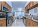 Modern kitchen with stainless steel appliances, granite countertops, and wood cabinets, open to the dining area at 1210 Wolford Dr, Trinity, FL 34655