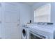 Laundry area featuring a modern washer and dryer, a white door, and a window for natural light at 1210 Wolford Dr, Trinity, FL 34655
