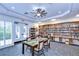 Inviting library space featuring a table with chairs, a ceiling fan, and extensive bookshelves at 1210 Wolford Dr, Trinity, FL 34655