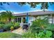 Cozy outdoor patio with an umbrella table and well-maintained landscaping and various potted plants at 1210 Wolford Dr, Trinity, FL 34655