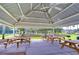 Outdoor picnic area featuring multiple picnic tables under a covered pavilion and barbecue grills at 1210 Wolford Dr, Trinity, FL 34655