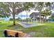 Community shuffleboard court with bench seating, nestled among lush greenery, offering a recreational outdoor space at 1210 Wolford Dr, Trinity, FL 34655