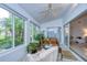 Bright sunroom offering large windows and a sliding door, enhanced by plants, and comfortable seating at 1210 Wolford Dr, Trinity, FL 34655
