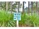 Golf course sign indicating tee and practice range amidst natural landscaping and greenery at 1210 Wolford Dr, Trinity, FL 34655