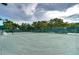 A community tennis court surrounded by lush trees, offering an active outdoor lifestyle at 1210 Wolford Dr, Trinity, FL 34655