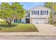 Charming two-story home with a well-manicured lawn and a two-car garage on a sunny day at 12222 Meadowbrook Ln, Hudson, FL 34667