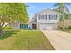Beautiful two-story home with a well-kept lawn, mature trees, and a welcoming facade at 12222 Meadowbrook Ln, Hudson, FL 34667