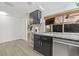 Well-lit kitchen features granite countertops, black cabinetry, and a window to an adjacent living space at 12222 Meadowbrook Ln, Hudson, FL 34667
