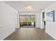 Bright living room with wood floors and sliding glass doors to outdoor living at 12222 Meadowbrook Ln, Hudson, FL 34667