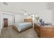 Comfortable main bedroom features a woven headboard, chandelier, and lots of natural light at 12222 Meadowbrook Ln, Hudson, FL 34667
