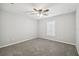 The carpeted bedroom features a ceiling fan and a window with shutters at 13227 Quigley Ave, Weeki Wachee, FL 34614