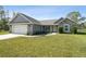 Charming single-story home featuring stone accents, a two-car garage, and a well-manicured lawn at 13227 Quigley Ave, Weeki Wachee, FL 34614