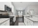 Well-lit kitchen boasting granite countertops, white cabinets, and stainless steel appliances at 13227 Quigley Ave, Weeki Wachee, FL 34614