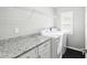 Laundry room featuring white cabinets, granite countertops, front load washer, and dryer at 13227 Quigley Ave, Weeki Wachee, FL 34614
