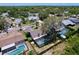A stunning aerial view highlights the property's screened-in pool, verdant landscaping, and neighborhood layout at 1445 Stonehenge Way, Palm Harbor, FL 34683