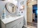 Bathroom featuring nautical accents, a round mirror, and vanity with cabinets and drawers at 1445 Stonehenge Way, Palm Harbor, FL 34683