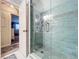 Bathroom featuring a glass enclosed shower with blue tiling, a double door, and soft lighting at 1445 Stonehenge Way, Palm Harbor, FL 34683