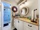 Bathroom vanity with granite countertop, modern fixtures and a view of the tiled shower at 1445 Stonehenge Way, Palm Harbor, FL 34683