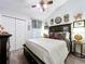 Bedroom with neutral colors, ceiling fan, and a decorative headboard with adjacent nightstand at 1445 Stonehenge Way, Palm Harbor, FL 34683