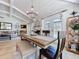 Dining room with wooden table, dining bench and chairs, light fixture, with view into the living room and pool at 1445 Stonehenge Way, Palm Harbor, FL 34683