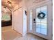 Bright entryway with a decorative seahorse, light-colored floors, and a glimpse into the kitchen at 1445 Stonehenge Way, Palm Harbor, FL 34683
