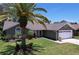 Inviting single-story home showcasing lush landscaping and a convenient two-car garage at 1445 Stonehenge Way, Palm Harbor, FL 34683