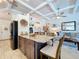 Open kitchen with island, granite countertops, and views into the bright living area at 1445 Stonehenge Way, Palm Harbor, FL 34683