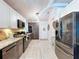 Kitchen featuring stainless steel refrigerator and appliances, granite countertops, wood cabinets, and white ceiling at 1445 Stonehenge Way, Palm Harbor, FL 34683