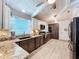Kitchen featuring tile backsplash, wood cabinets, stainless steel appliances, and white countertops at 1445 Stonehenge Way, Palm Harbor, FL 34683
