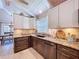 The kitchen includes stone countertops, stainless steel appliances, and a breakfast bar with seating for casual dining at 1445 Stonehenge Way, Palm Harbor, FL 34683