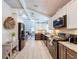 Bright, modern kitchen with stainless steel appliances, granite countertops, and wood tile floors at 1445 Stonehenge Way, Palm Harbor, FL 34683