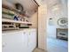 Functional laundry room equipped with a modern washer and dryer, shelving, and adjacent to a decorated hallway at 1445 Stonehenge Way, Palm Harbor, FL 34683