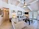 Comfortable living room featuring vaulted ceiling, chic decor, and seamless access to the outdoor patio at 1445 Stonehenge Way, Palm Harbor, FL 34683