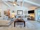 A cozy living room with two sofas, accent rug, coffee table and decor, and a ceiling fan with vaulted ceiling at 1445 Stonehenge Way, Palm Harbor, FL 34683