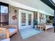 Inviting patio with comfortable seating, decorative turtle and 'BEACH' signage, and a view of lush surroundings at 1445 Stonehenge Way, Palm Harbor, FL 34683