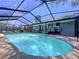 Expansive screened-in pool area, perfect for relaxation and entertainment, surrounded by lush landscaping at 1445 Stonehenge Way, Palm Harbor, FL 34683