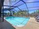 Refreshing swimming pool with a screened enclosure, spacious patio, and comfortable lounge chairs at 1445 Stonehenge Way, Palm Harbor, FL 34683