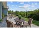 Covered patio with a round table and seating, overlooking beautiful green landscaping at 14855 Renaissance Ave, Odessa, FL 33556