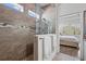 Modern bathroom showcasing a glass shower with neutral tile and pebble flooring at 14855 Renaissance Ave, Odessa, FL 33556