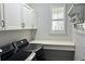 Laundry room with black washer/dryer, white countertop space and built in storage cabinets at 14855 Renaissance Ave, Odessa, FL 33556