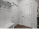 Mud room with white bench seating and three white painted doors at 14855 Renaissance Ave, Odessa, FL 33556